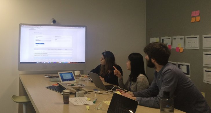 A user-testing session, the team watching the platform on a large screen